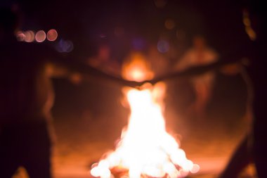 İnsanlar ateşin etrafında dans