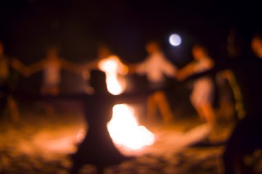 İnsanlar ateşin etrafında dans