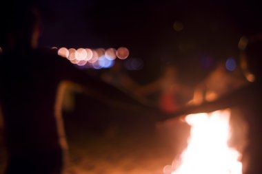 İnsanlar ateşin etrafında dans