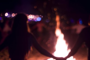 İnsanlar ateşin etrafında dans