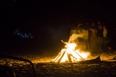 İnsanlar ateşin etrafında dans