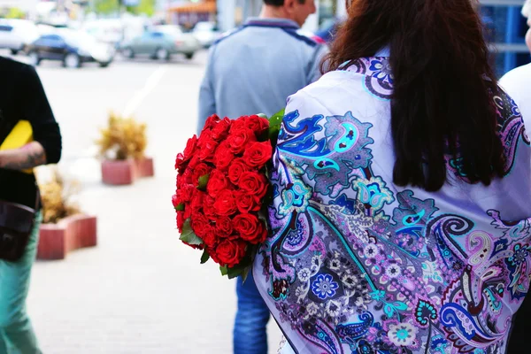 Beautiful girl with long hair with a large bouquet of roses — Stock Photo, Image