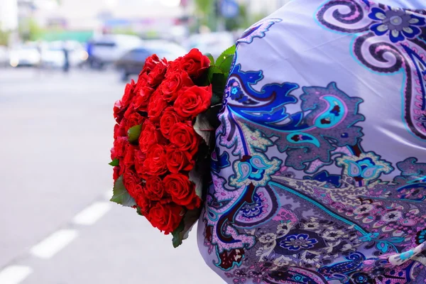 Beautiful girl with long hair with a large bouquet of roses — Stock Photo, Image