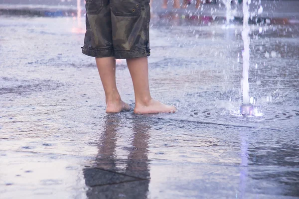 Nogi, dzieci, zabawy z fontanną strzał w okresie letnim — Zdjęcie stockowe