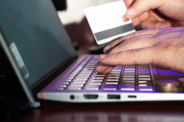 Bir dizüstü bilgisayarda kredi kartı ve tükenmez kalem