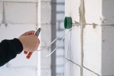 İşçi duvara plastik elektrik kutusu yerleştiriyor