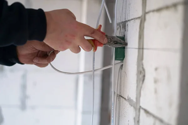 Worker installing the plastic electrical box on the wall
