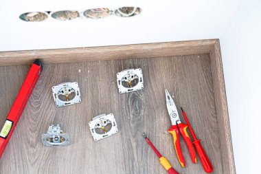 Yeşil duvarda parke döşemeli elektrik prizi var.