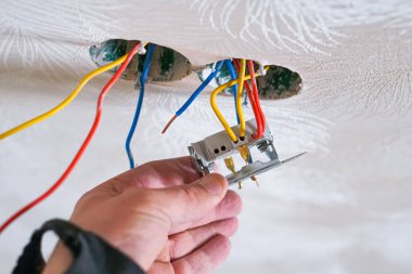 Alçıtaşı duvarına soket takan elektrikçinin elleri