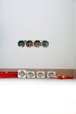 Yeşil duvarda parke döşemeli elektrik prizi var.