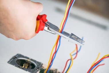 Alçıtaşı duvarına soket takan elektrikçinin elleri