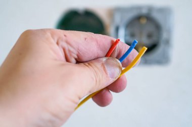 Alçıtaşı duvarına soket takan elektrikçinin elleri