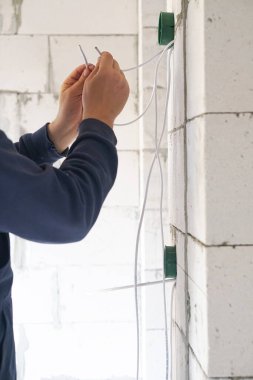 İşçi duvara plastik elektrik kutusu yerleştiriyor