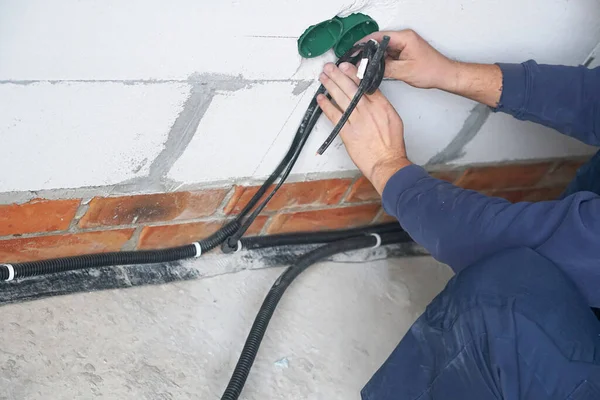 Worker installing the plastic electrical box on the wall