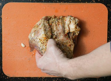 Elinde çiğ et tutan Olgun Adam.