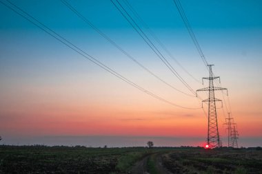Elektrik direği, gün batımı gökyüzü, şafak vakti ağacın gölgesinde elektrik direği, günbatımında fotokopi uzayı ile elektrik iletim hattı.
