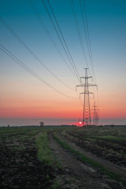 Elektrik direği, gün batımı gökyüzü, şafak vakti ağacın gölgesinde elektrik direği, günbatımında fotokopi uzayı ile elektrik iletim hattı.