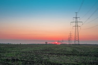 Elektrik direği, gün batımı gökyüzü, şafak vakti ağacın gölgesinde elektrik direği, günbatımında fotokopi uzayı ile elektrik iletim hattı.