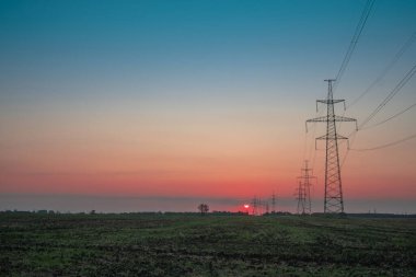 Elektrik direği, gün batımı gökyüzü, şafak vakti ağacın gölgesinde elektrik direği, günbatımında fotokopi uzayı ile elektrik iletim hattı.