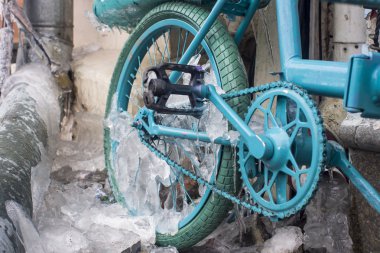 Park edilmiş bir bisiklet üzerinde oluşan buz buz sarkıtları mavi göz.