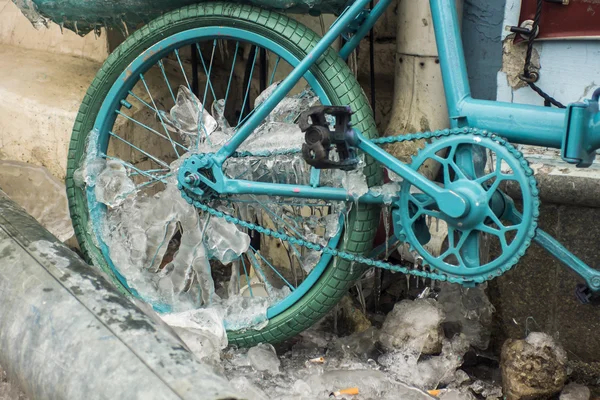 Blue look at ice icicles formed on a parked bicycle. — Stock Photo, Image