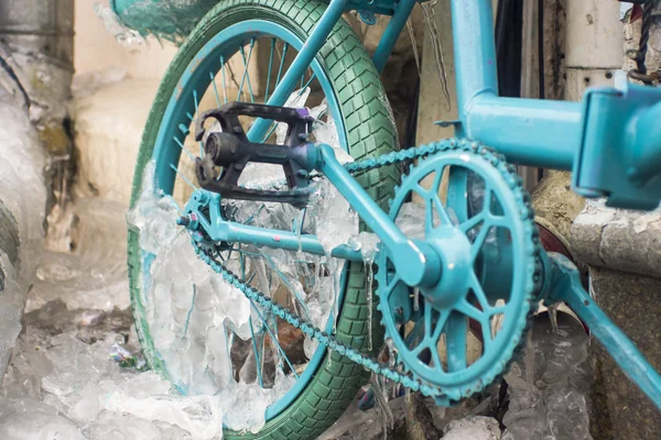 Park edilmiş bir bisiklet üzerinde oluşan buz buz sarkıtları mavi göz.