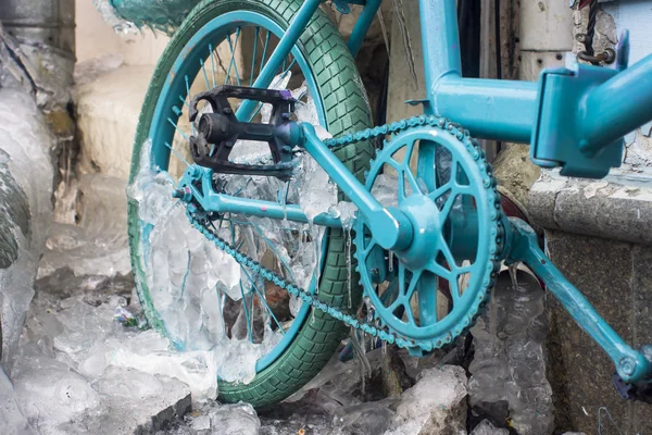 Park edilmiş bir bisiklet üzerinde oluşan buz buz sarkıtları mavi göz.