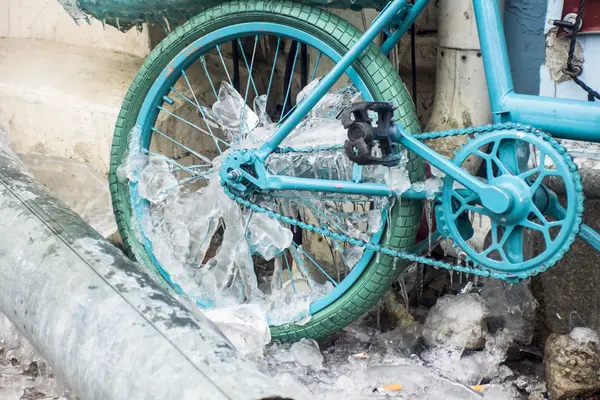 Azul olhar para gelo icicles formados em uma bicicleta estacionada . — Fotografia de Stock