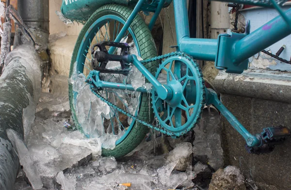 Park edilmiş bir bisiklet üzerinde oluşan buz buz sarkıtları mavi göz.