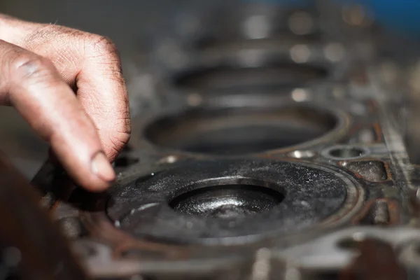 Mechanic hands tighten nut with wrench while repairing engine