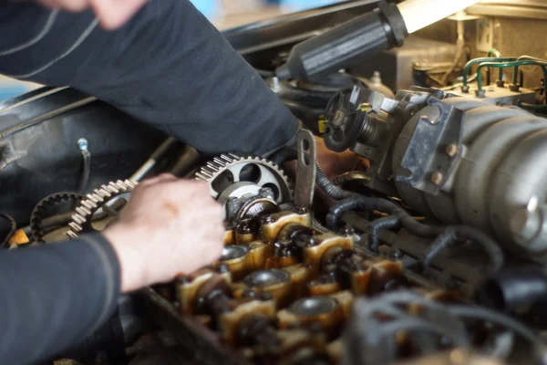 Dirty car mechanic hands examining car automobile at repair service station