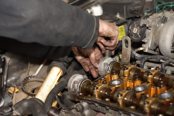 Smutsig bil mekaniker händer granska bil bil på reparation service station — Stockfoto