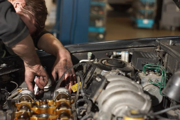 Mekaniker händer dra åt muttern med skiftnyckel medan du reparera motorn — Stockfoto
