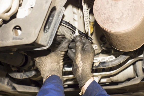 Dirty car mechanic hands examining car automobile at repair service station — Stock Photo, Image