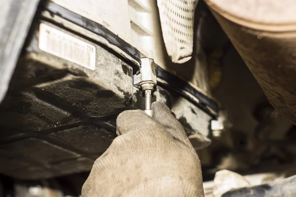 Dirty car mechanic hands examining car automobile at repair service station