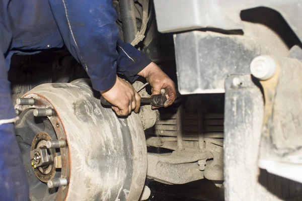 Smutsig bil mekaniker händer granska bil bil på reparation service station — Stockfoto