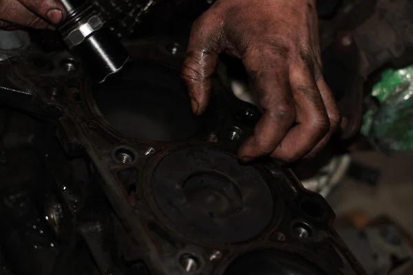Механічні руки затягують гайку ключем під час ремонту двигуна — стокове фото