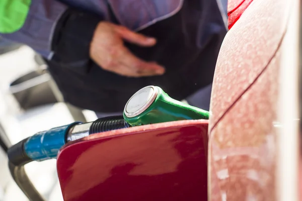 Mano masculina llenando el coche con combustible en una estación de servicio — Foto de Stock