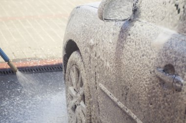 Akan su ve köpükle araba yıkama.