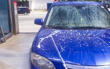 Akan su ve köpükle araba yıkama.