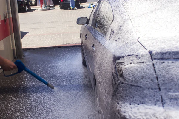 Lavagem de carro com água corrente e espuma. — Fotografia de Stock