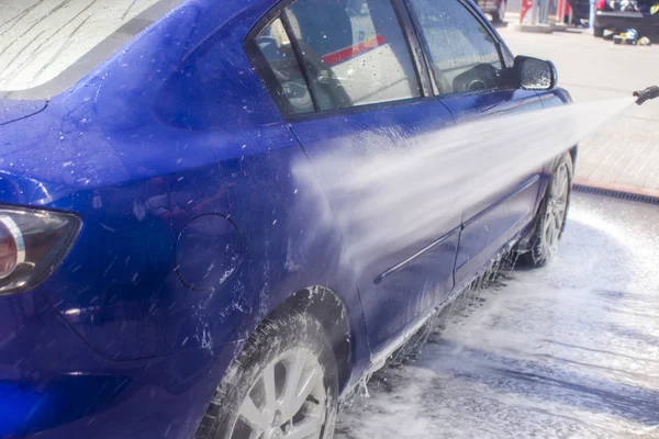 Biltvätt med rinnande vatten och skum. — Stockfoto