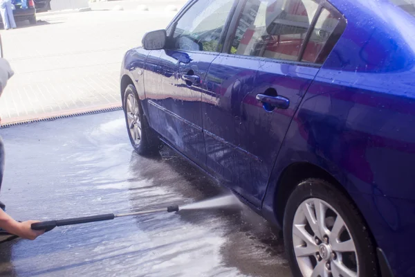 Myjnia samochodowa z płynącą wodą i pianką. — Zdjęcie stockowe