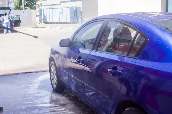 Lavagem de carro com água corrente e espuma. — Fotografia de Stock