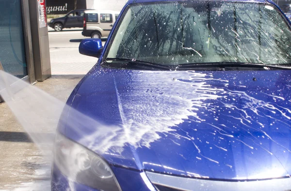 Lavagem de carro com água corrente e espuma. — Fotografia de Stock