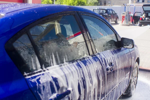 Akan su ve köpükle araba yıkama. — Stok fotoğraf