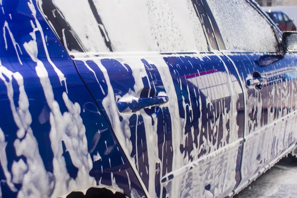 Carwash met stromend water en schuim. — Stockfoto