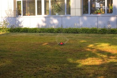 Yağmurlama kafa yeşil çim üzerinde su püskürtme.