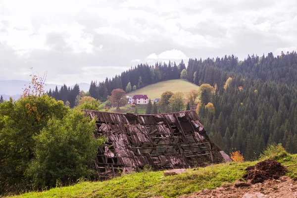 Das Dach der alten Karpaten im Vordergrund und im Hintergrund ein Dorf in den Bergen — Stockfoto