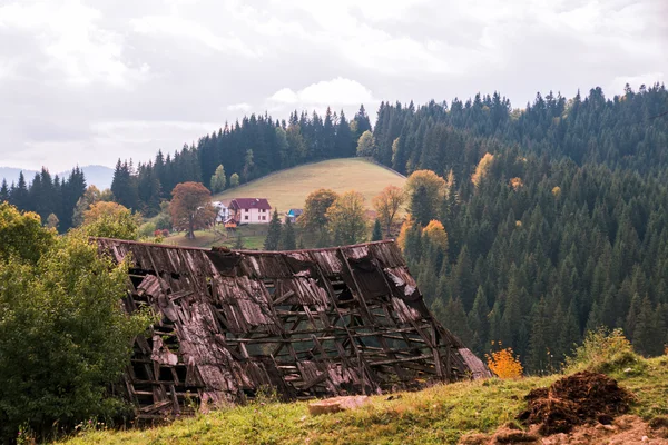 Das Dach der alten Karpaten im Vordergrund und im Hintergrund ein Dorf in den Bergen — Stockfoto